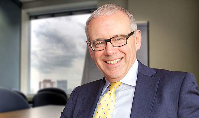 Nigel smiling in a blue suit