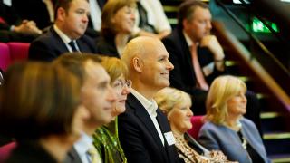 Group of business professionals listening to a presentation.