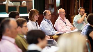 Group of people listening to a speaker.