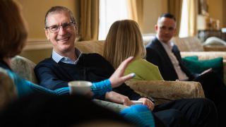 Group of people sitting on sofas chatting.