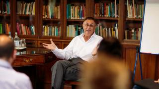 Man in white shirt speaking to others in a consultation