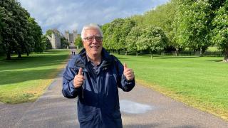 Alan Coppin, in blue rain coat holding two thumbs up.