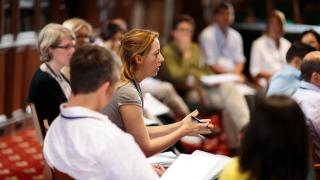 A woman talking to a group of co-workers.