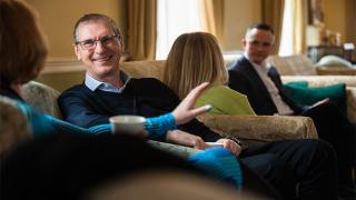 Man chatting to a women on a sofa