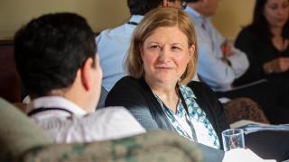 Woman talking to man on sofa.