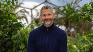 Simon smiling in blue jumper