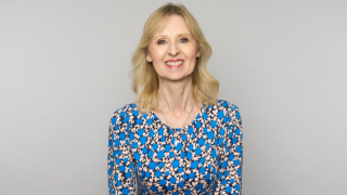 jane hughes on grey background smiling at camera