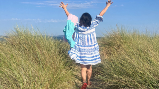 lady in field with arms in the air
